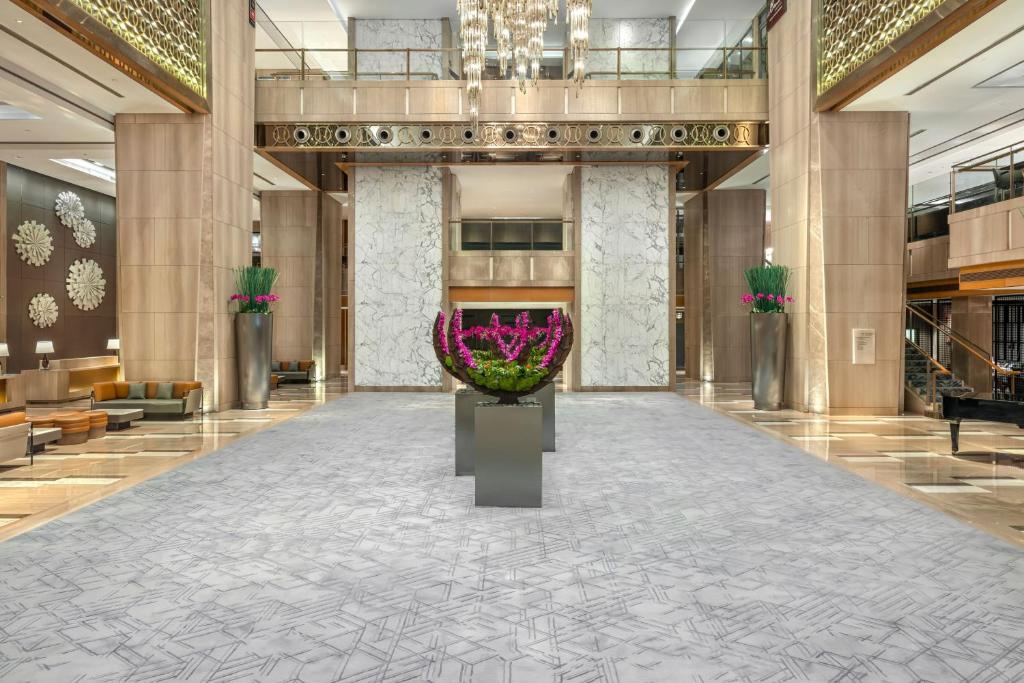um lobby com um grande vaso de flores no meio em Sheraton Guangzhou Hotel em Guangzhou
