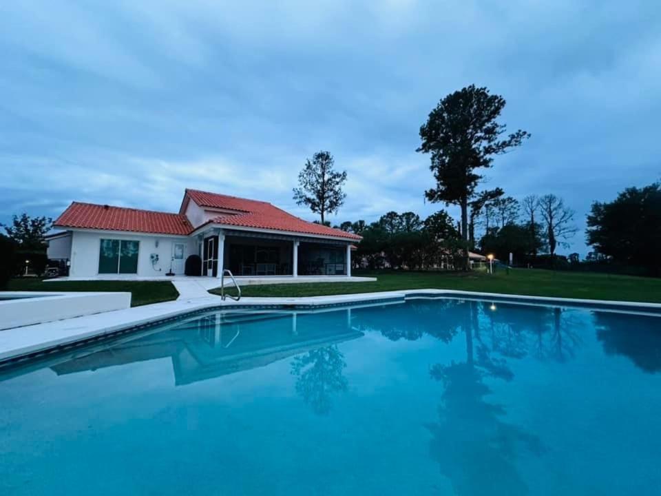 a swimming pool in front of a house at SWISS 24 - Lake Stephanie in Clermont