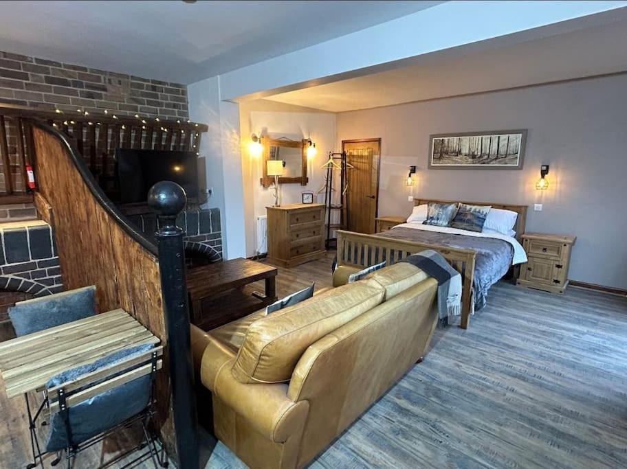 salon z łóżkiem i kanapą w pokoju w obiekcie Stables Wem w mieście Wem