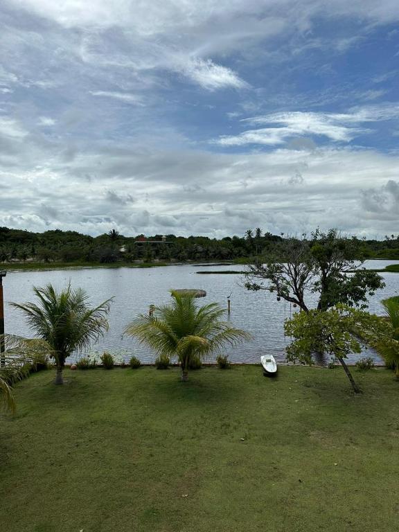 um lago com palmeiras e um barco na relva em Brisa da lagoa em Paracuru