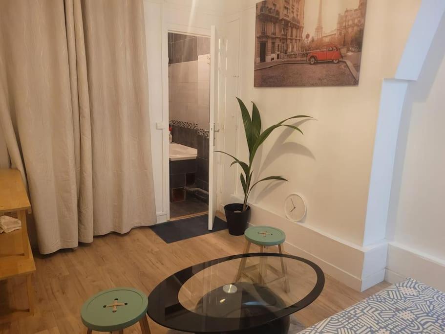 - un salon avec une table en verre et deux tabourets dans l'établissement Charmant appartement près de Montmartre, à Paris