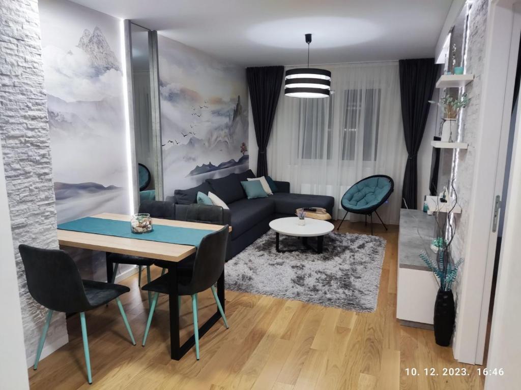 亞霍里納的住宿－Apartman Kaja (ski-to-door, Jahorina)，客厅配有沙发和桌子