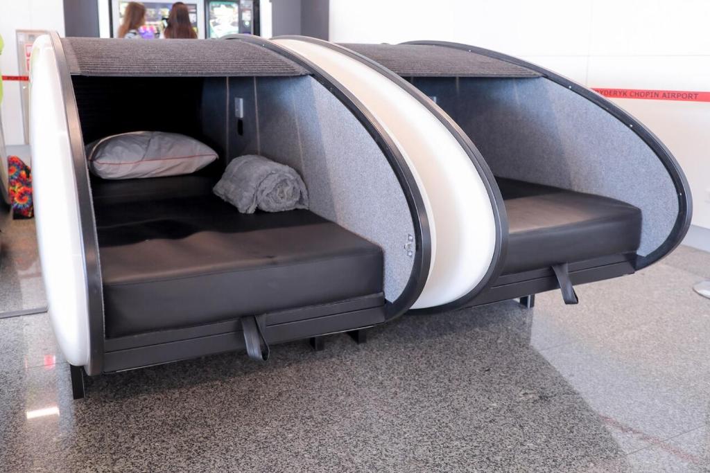 a room with two seats in a building with a bed at Sleeping Pods GoSleep - Inside of Warsaw Chopin Airport, non schengen restricted zone after passport control, near Gate 2N in Warsaw