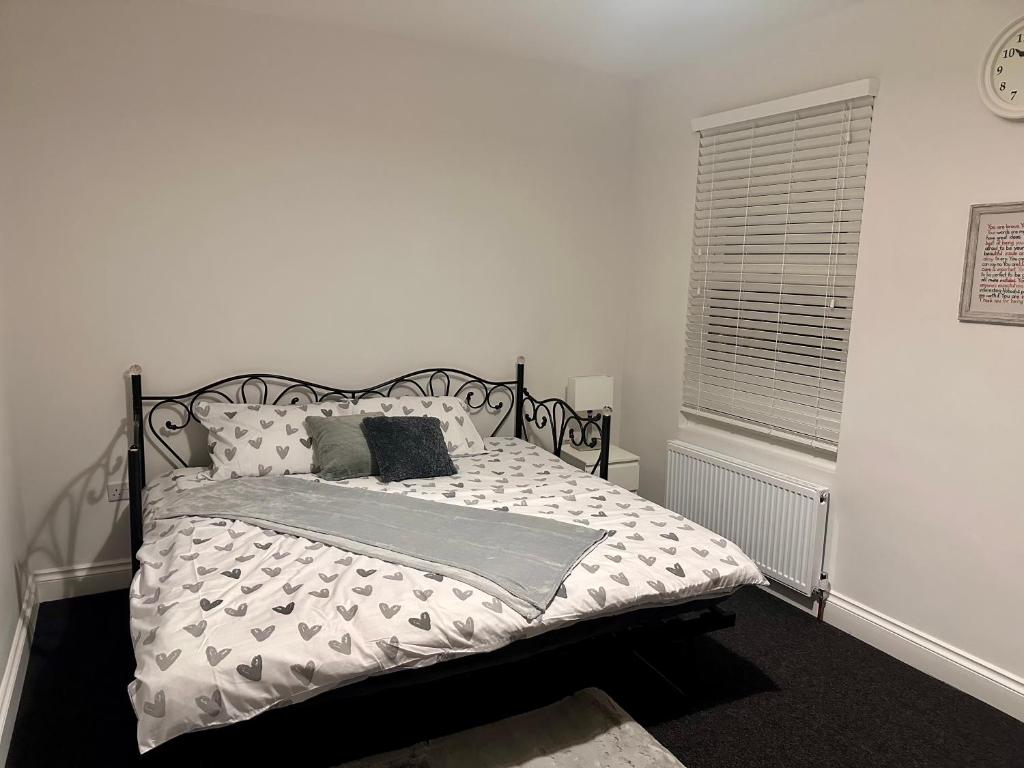 a bedroom with a bed with a black and white comforter at Dunedin Heights in London