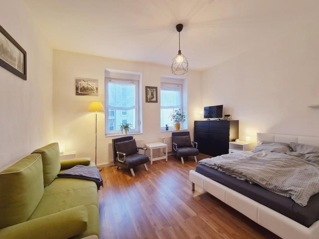 愛爾福特的住宿－Suite am Park，一间卧室配有一张床、一张沙发和椅子