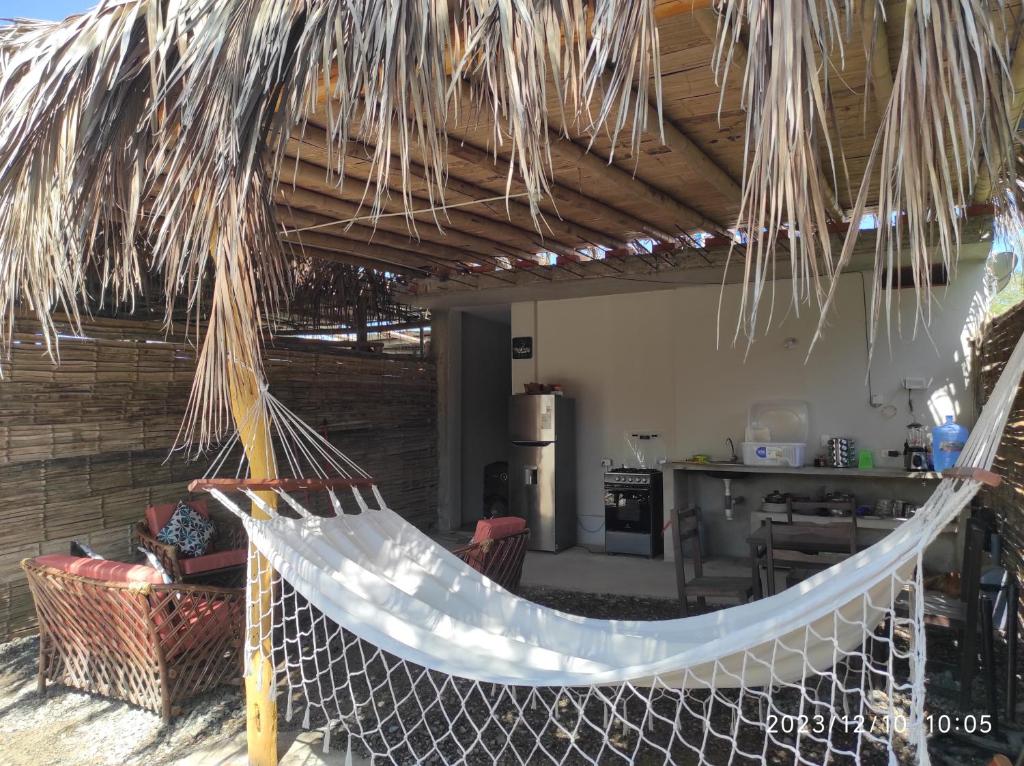 a hammock in a house with a kitchen at La casa de Joan in Máncora