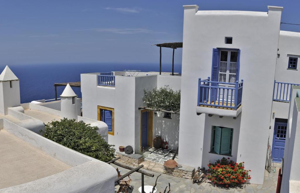 un gruppo di edifici bianchi con porte e finestre blu di Kyma sto Phos a Chora Folegandros