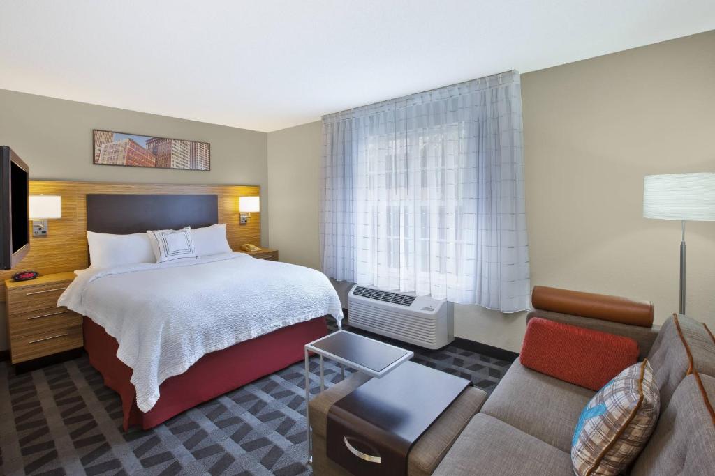 a hotel room with a bed and a couch at TownePlace Suites by Marriott Brookfield in Brookfield