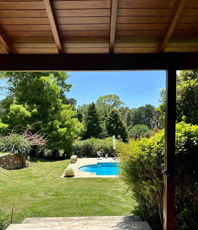 a view of a yard with a swimming pool at Duplex al Golf Sierra de los Padres in Sierra de los Padres
