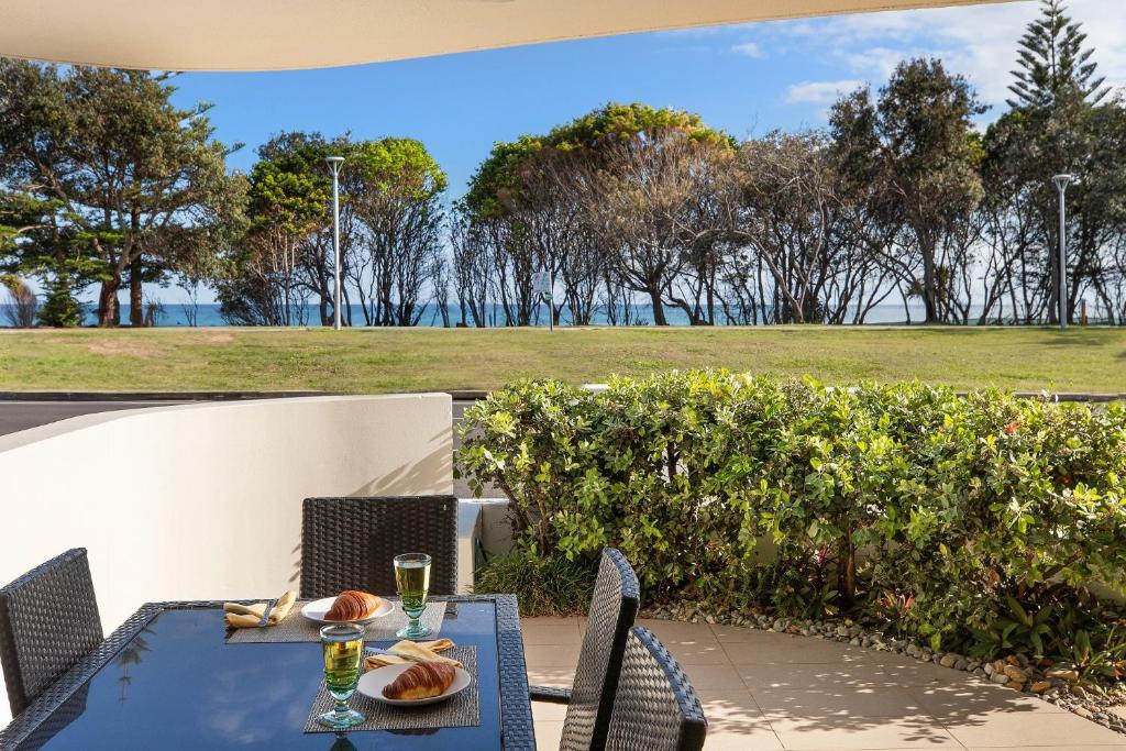 バイロンベイにあるWaterview Beachside Apartment - Palms 2の田園の景色を望むパティオ(テーブル、椅子付)