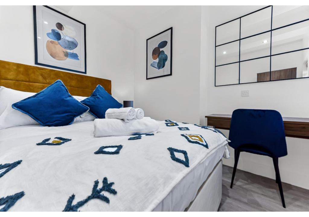 - une chambre avec un lit et une chaise bleue dans l'établissement Modern Apartment Where Everything Just Works!, à Londres