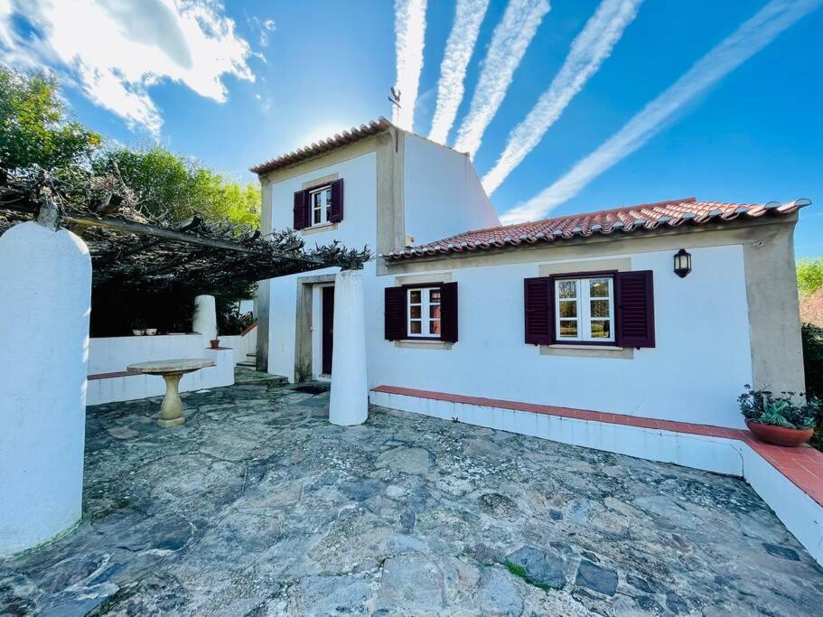 ein weißes Haus mit schwarzen Rollläden und einer Terrasse in der Unterkunft Casa do Reguengo (New!) in Castelo de Vide