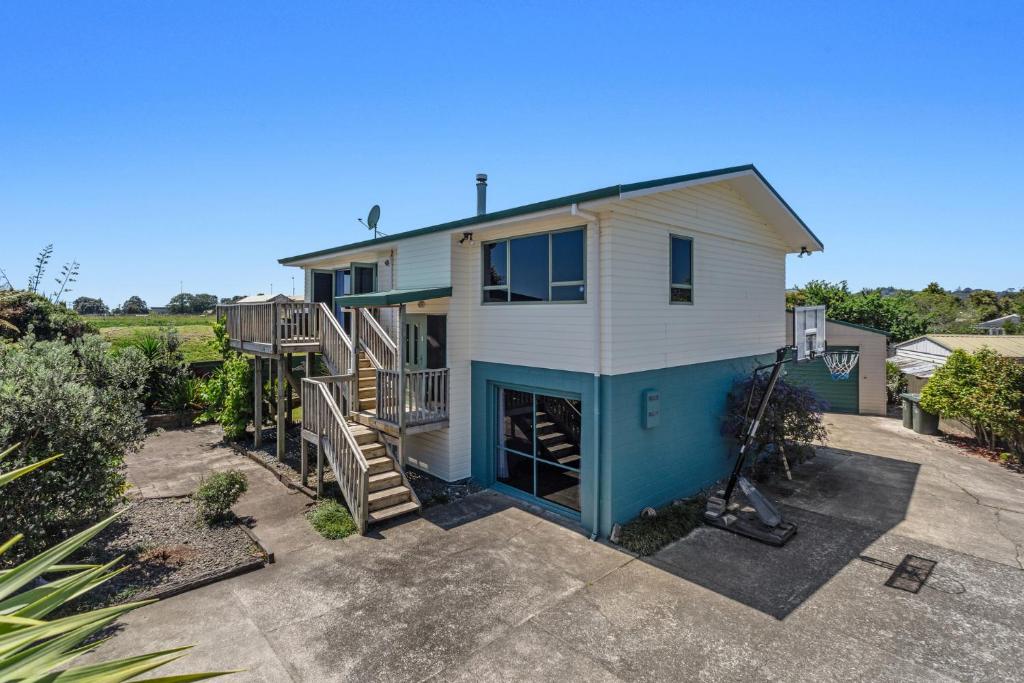 a large house with a staircase and a yard at Heavenly on Riverside - Whakatāne Holiday Home in Whakatane