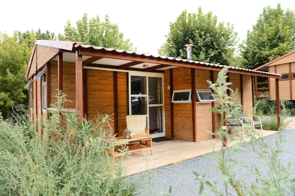 een houten hut met een terras in een tuin bij BUNGALOW in Lavergne