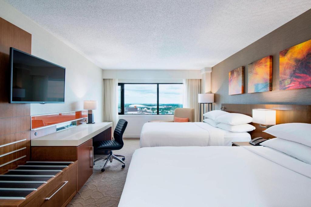 a hotel room with two beds and a flat screen tv at Delta Hotels by Marriott Regina in Regina