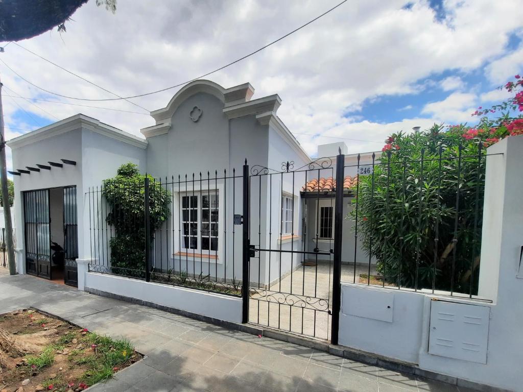 Uma casa branca com um portão à frente. em Casa en Salta em Salta