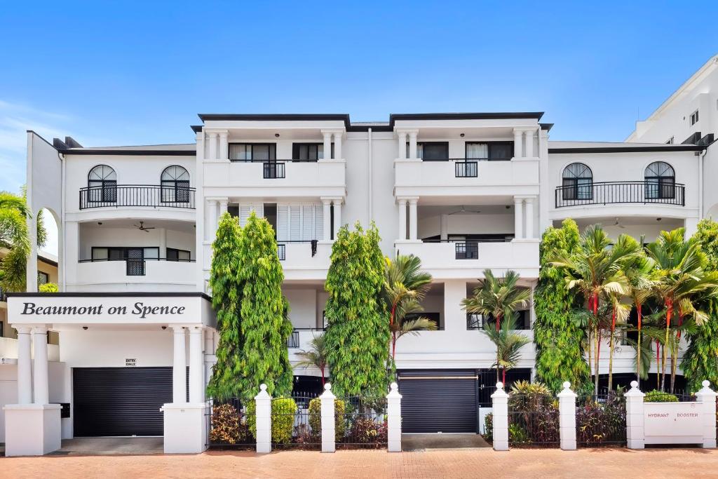 a white building with trees in front of it at Spacious 3 Bedroom Townhouse in Cairns City in Cairns