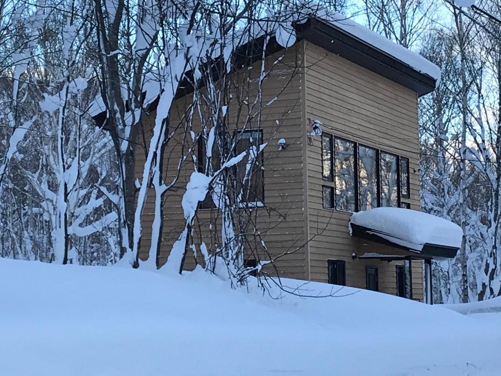 a house covered in snow next to a pile of snow at Forest Hideaway - Vacation STAY 09982v in Niseko