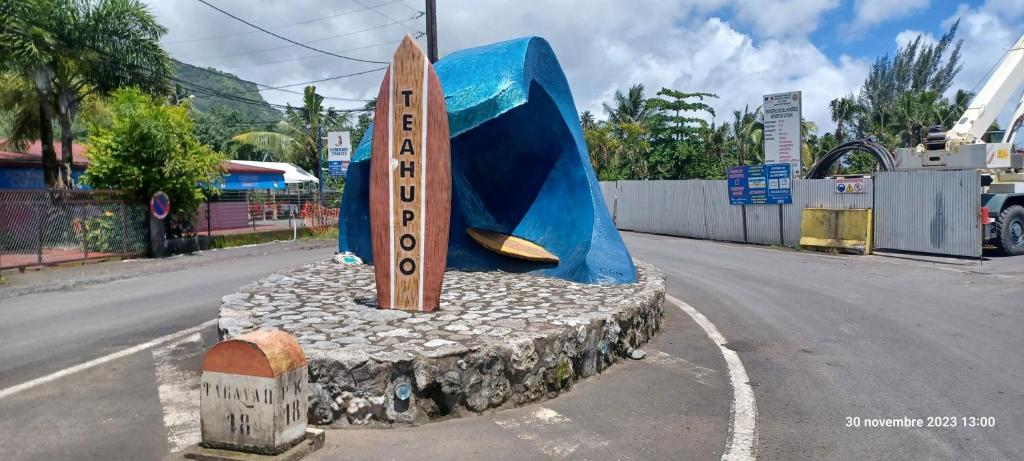 una tabla de surf de madera sobre una carretera en Havae Lodge, en Teahupoo