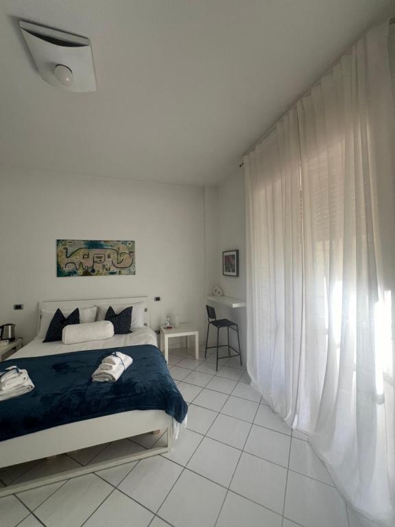 een witte slaapkamer met een bed met een blauwe deken bij Suite 84 Holiday Home in Salerno