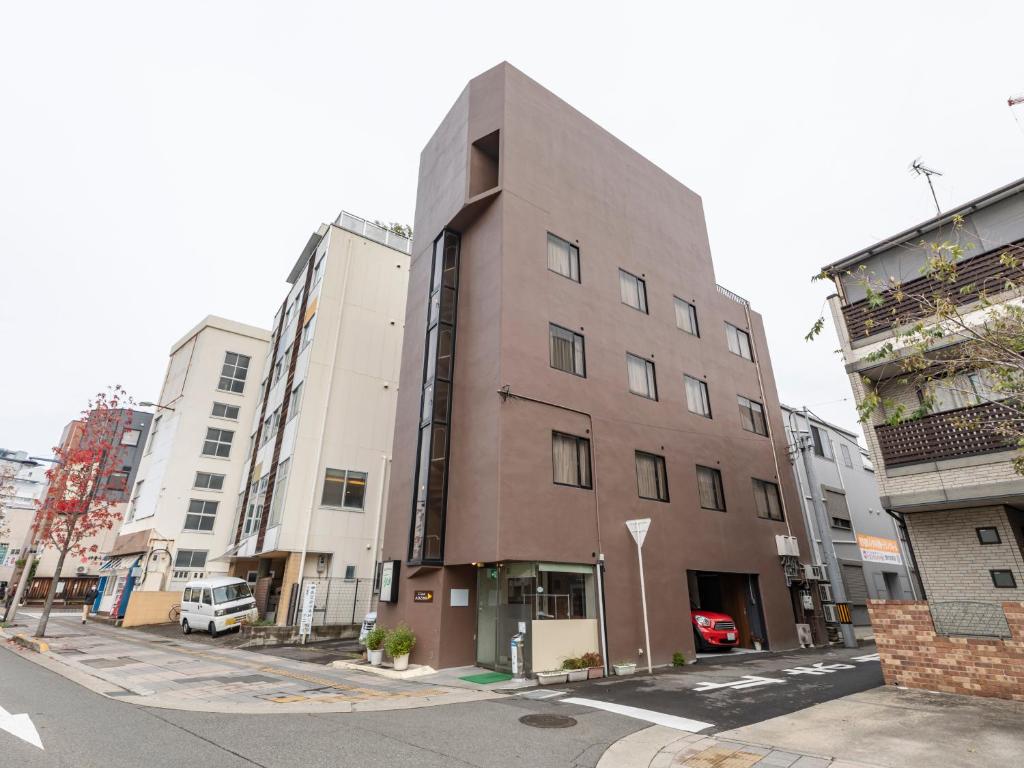 a tall brown building on a city street at Tabist New Gekkoen in Shimminatomachi