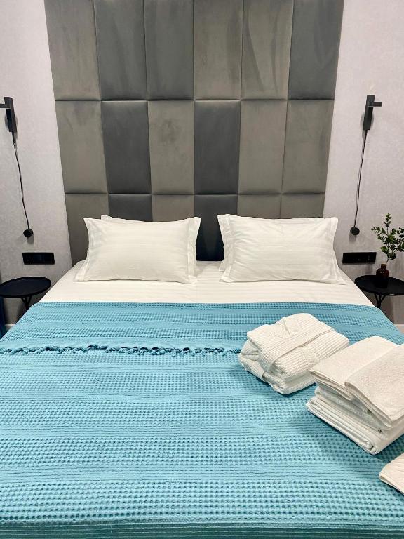 a bed with two pillows and towels on it at Landmark Astana 2 комнатные апартаменты in Astana