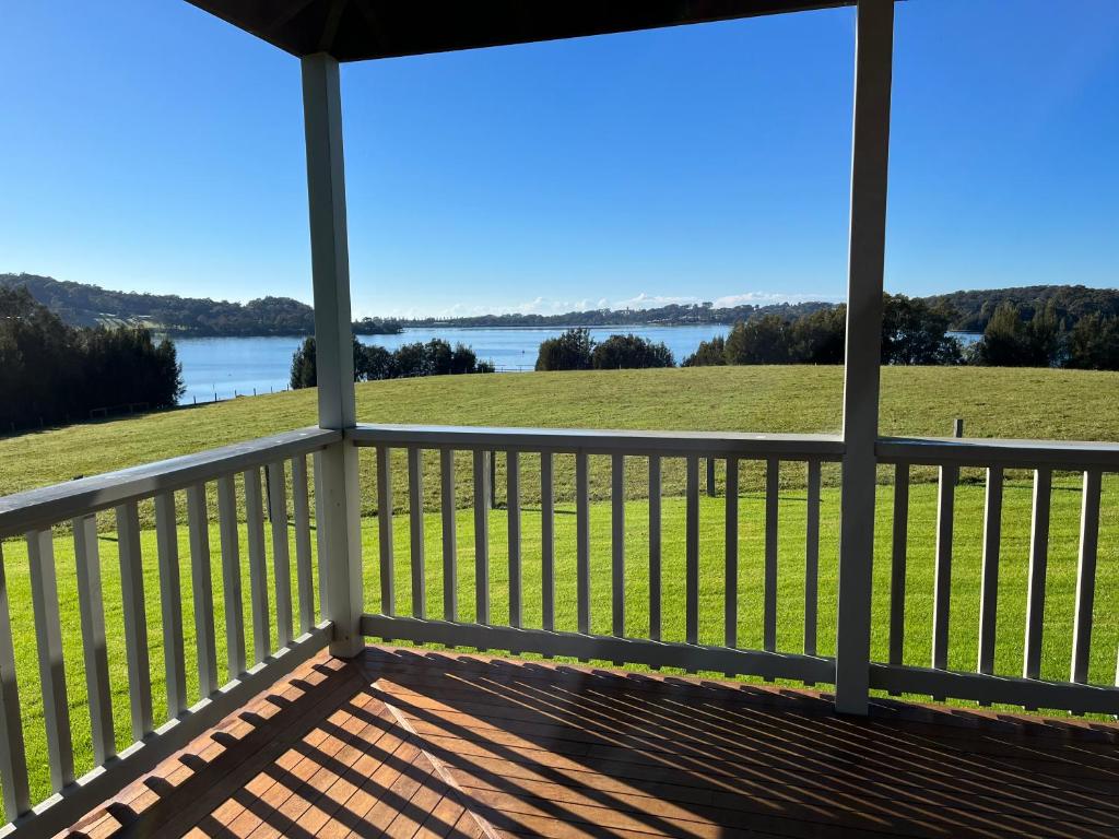 a screened in porch with a view of the water at Black Bream Point Cabins in Narooma