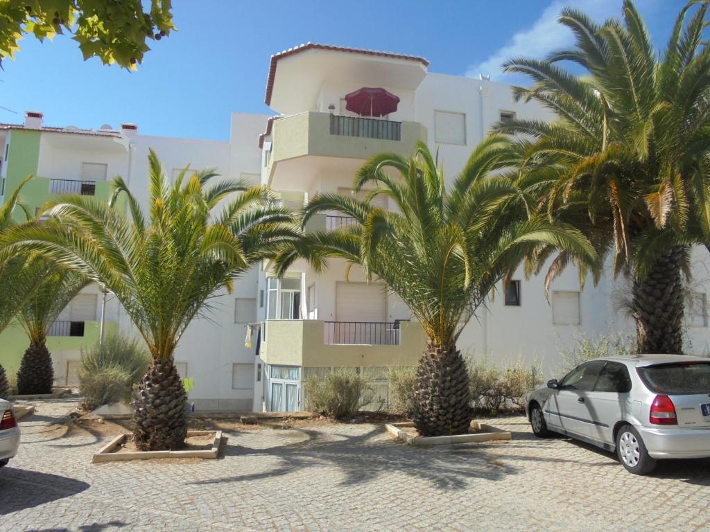 a car parked in front of a building with palm trees at Casa Ameijeira in Lagos