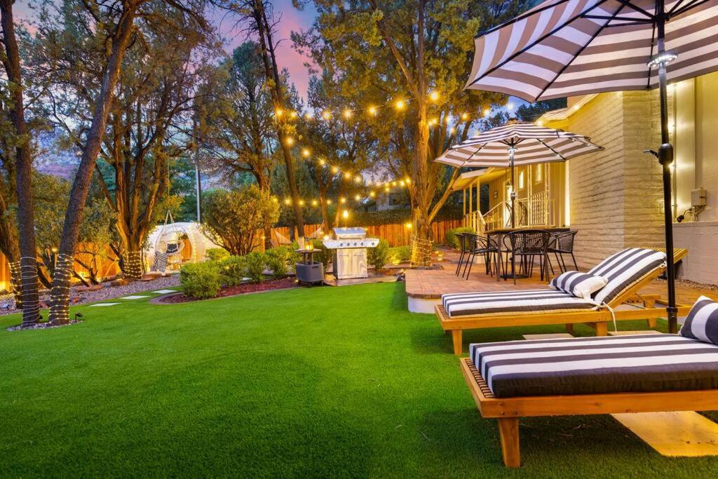 um quintal com cadeiras e guarda-sóis num relvado em *NEW* The Sedona Villa: Resort Backyard/Hot Tub/Golf em Sedona