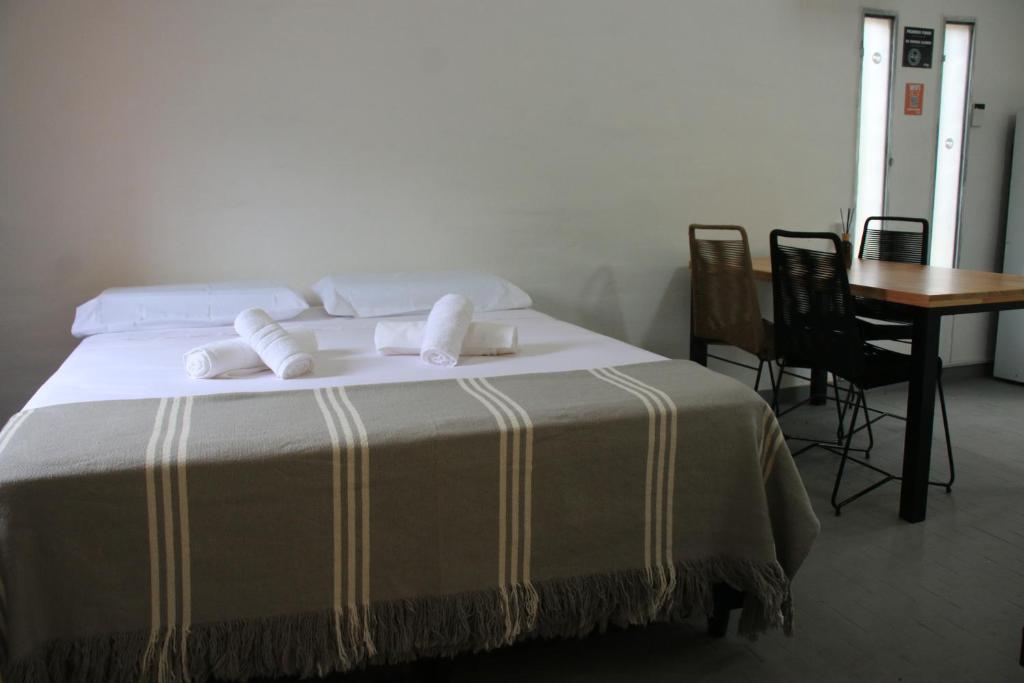 1 dormitorio con 1 cama con mesa y sillas en BROTHERS HOSTEl en Villa Allende