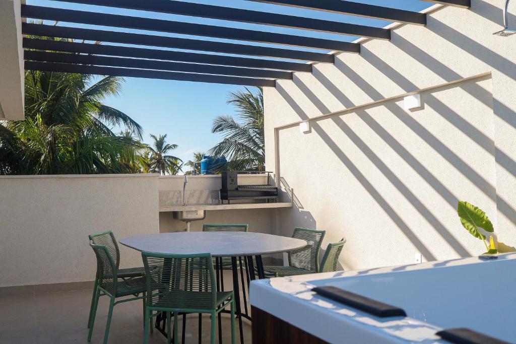 a patio with a table and chairs on a balcony at The Home São Miguel do Gostoso by Liiv in São Miguel do Gostoso