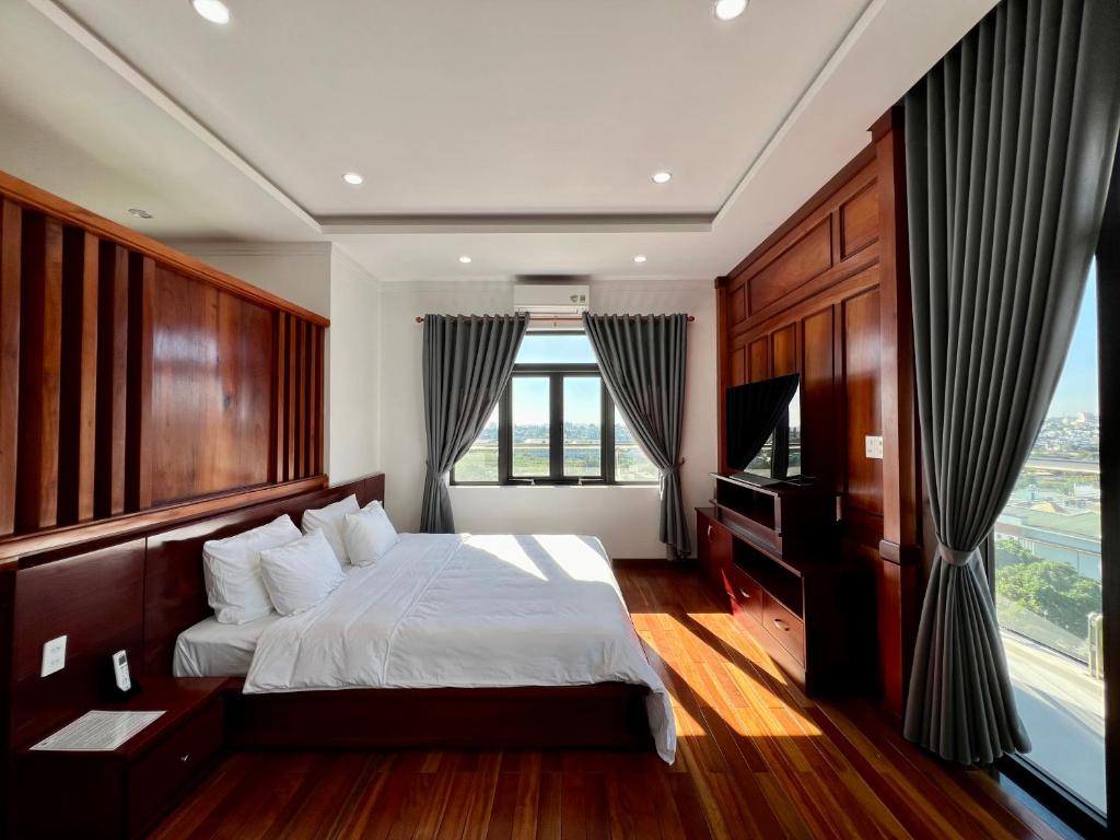 a bedroom with a bed and a large window at Đoàn Gia Luxury House in Pleiku