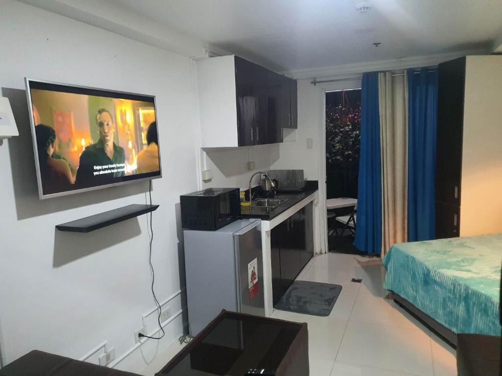eine Küche mit einem TV an der Wand eines Zimmers in der Unterkunft Baguio Bliss by Burnham Hill Condominium in Baguio City
