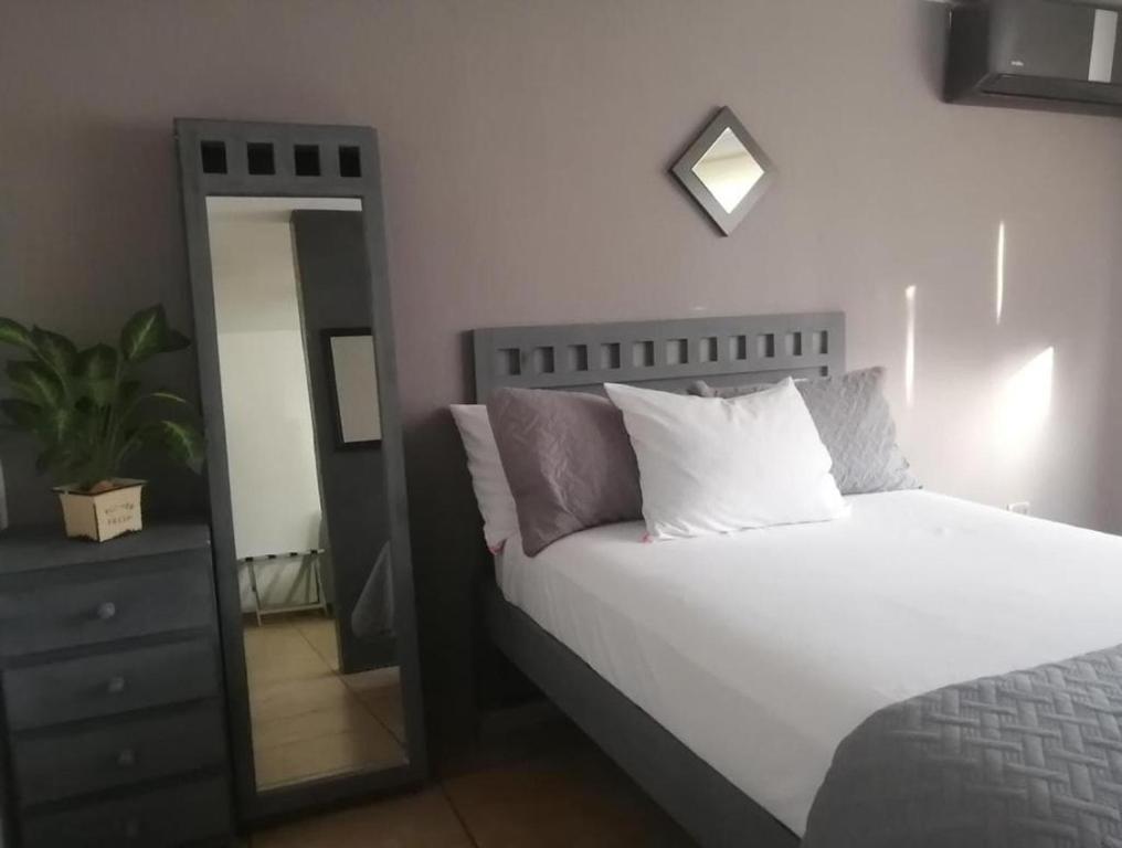 a bedroom with a white bed and a mirror at La Luna in Cancún