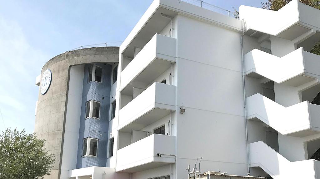 a white building with a clock on the side of it at Global Resort Miyajima View in Hatsukaichi