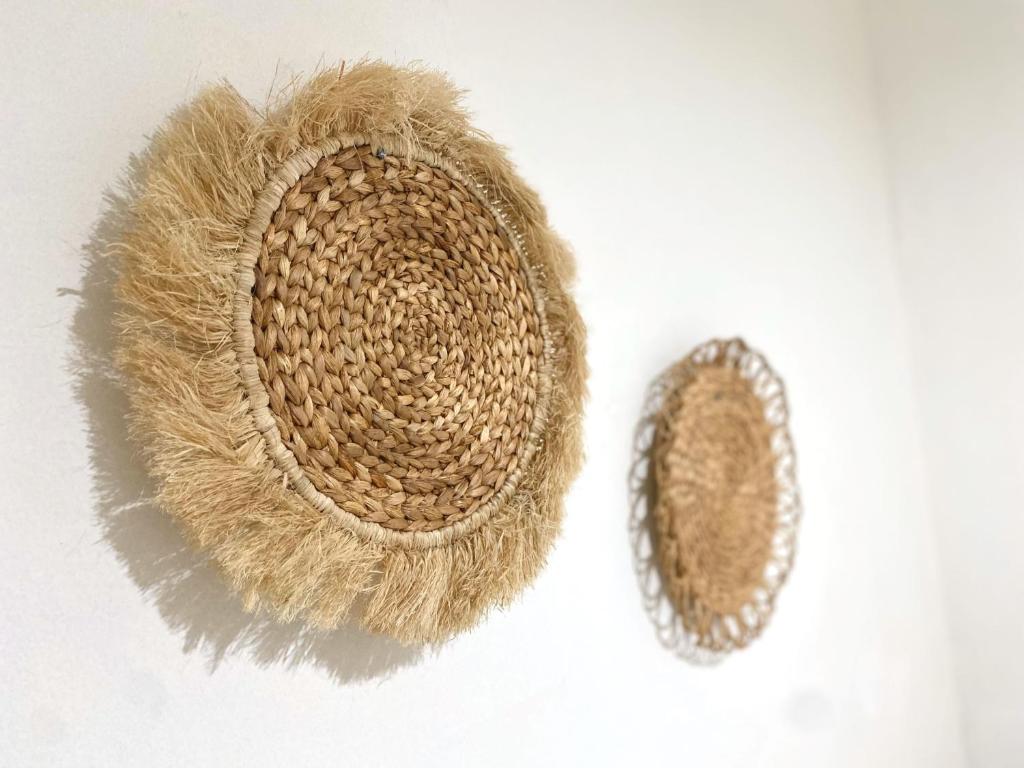 a pair of hats sitting on a white wall at El Sierra Villa in Pontianak