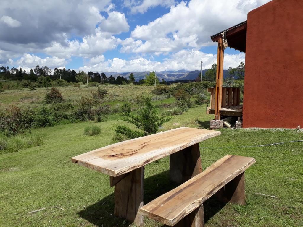 a wooden bench sitting on top of a field at El Camino Suites in Villa Berna