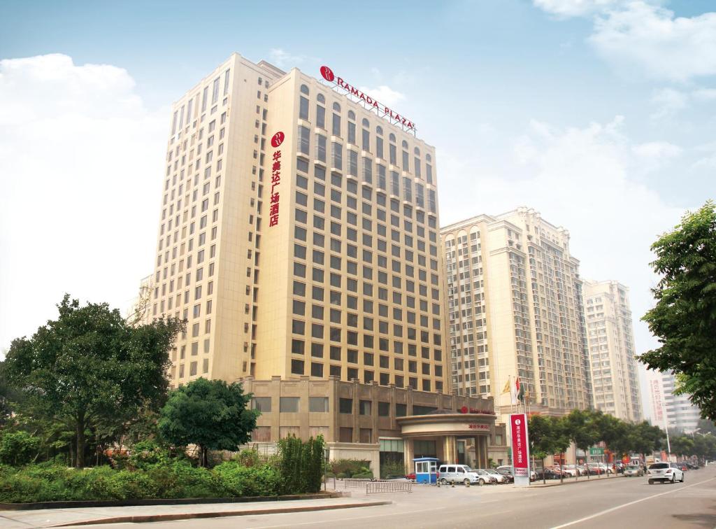 un grand bâtiment avec un panneau sur son côté dans l'établissement Ramada Plaza Weifang, à Weifang