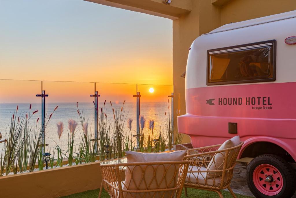 uma caravana estacionada na praia com um pôr-do-sol em Hound Hotel Ulsan em Ulsan