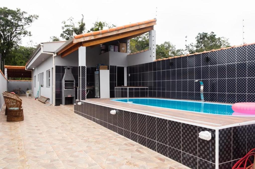 a house with a swimming pool in the backyard at Casa Praia Itanhaém - Avenida Santos in Itanhaém