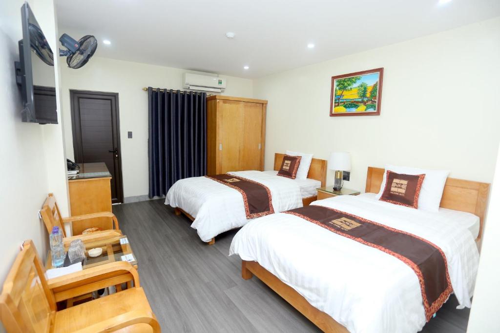 a hotel room with two beds and a television at HOA CƯƠNG HOTEL 2 (HÀ GIANG) in Ha Giang