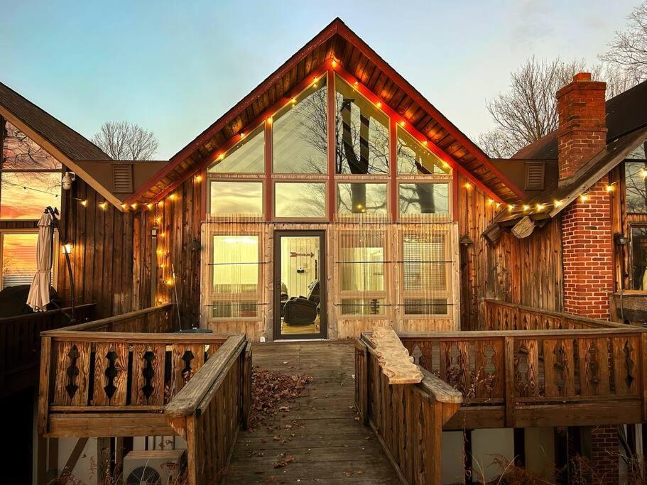 a house with a deck with lights on it at Cozy Indian Lake Chalet on Golf Course with Arcade/Gameroom in Stoystown