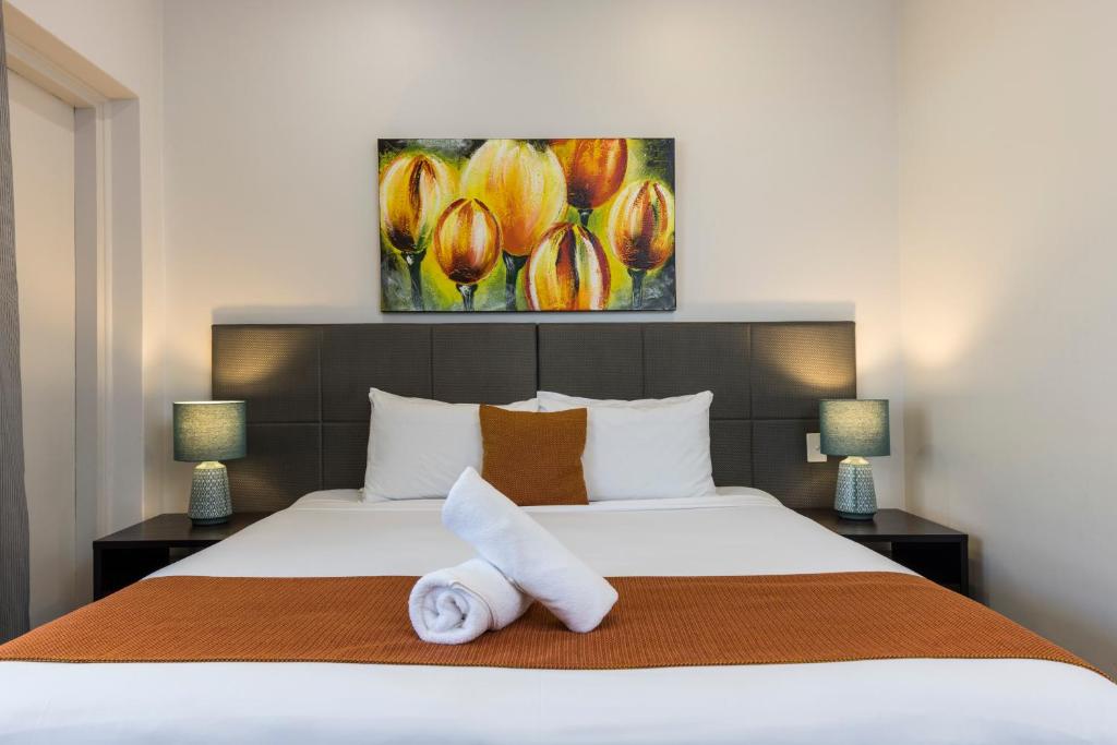 a bedroom with a bed with a towel on it at The Abbott Boutique Hotel in Cairns