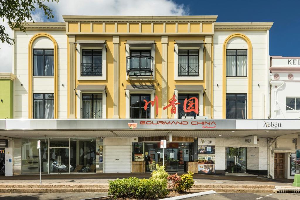 a yellow building on a street in front of a building at The Abbott Boutique Hotel in Cairns