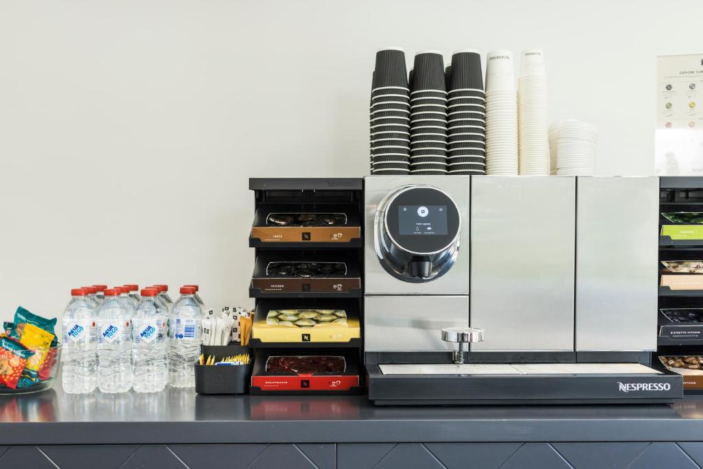 a kitchen with a counter with plates and water bottles at The Abbott Boutique Hotel in Cairns