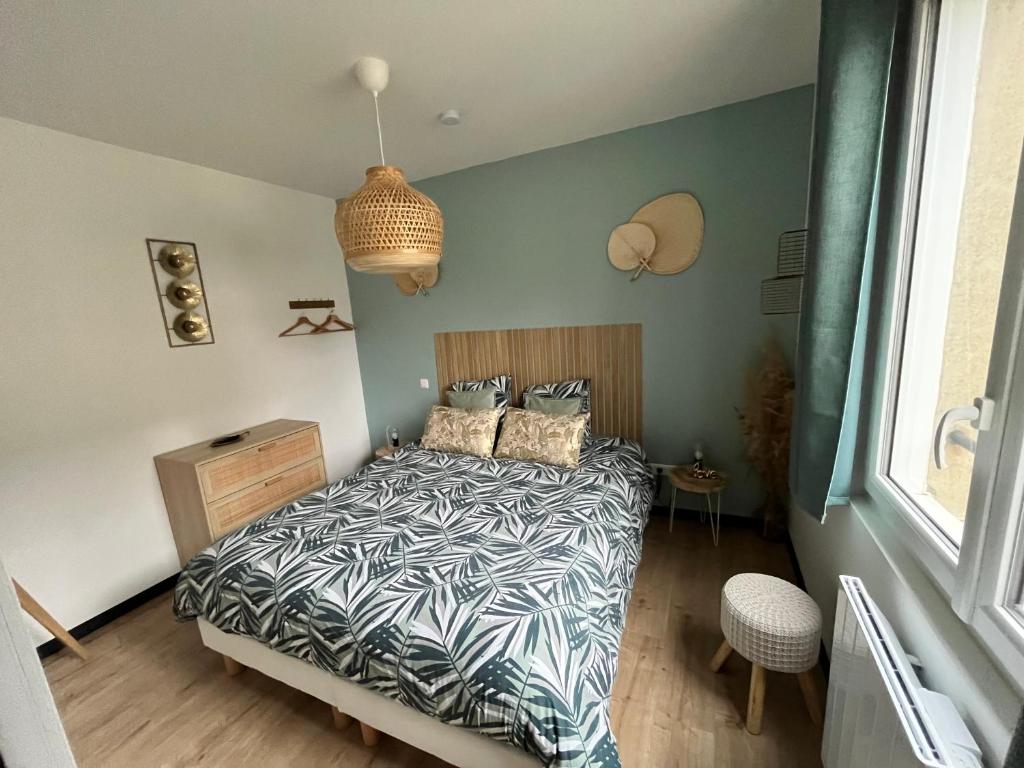 una camera da letto con un letto con un piumone bianco e nero di Coin de paradis avec spa illimité en plein centre Avranches ad Avranches