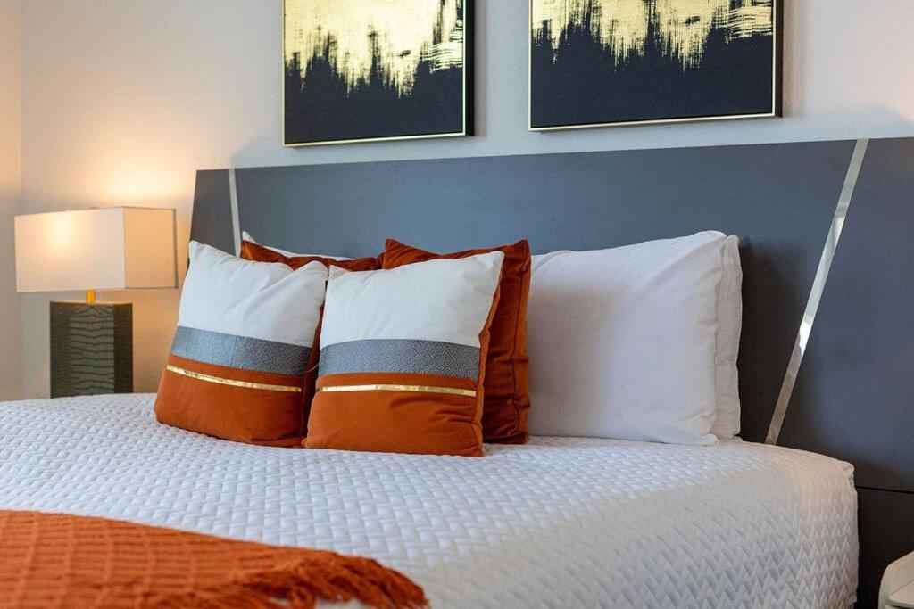 基西米的住宿－Disney/Epcot/Reunion Golf Course，卧室内的一张带橙色和白色枕头的床
