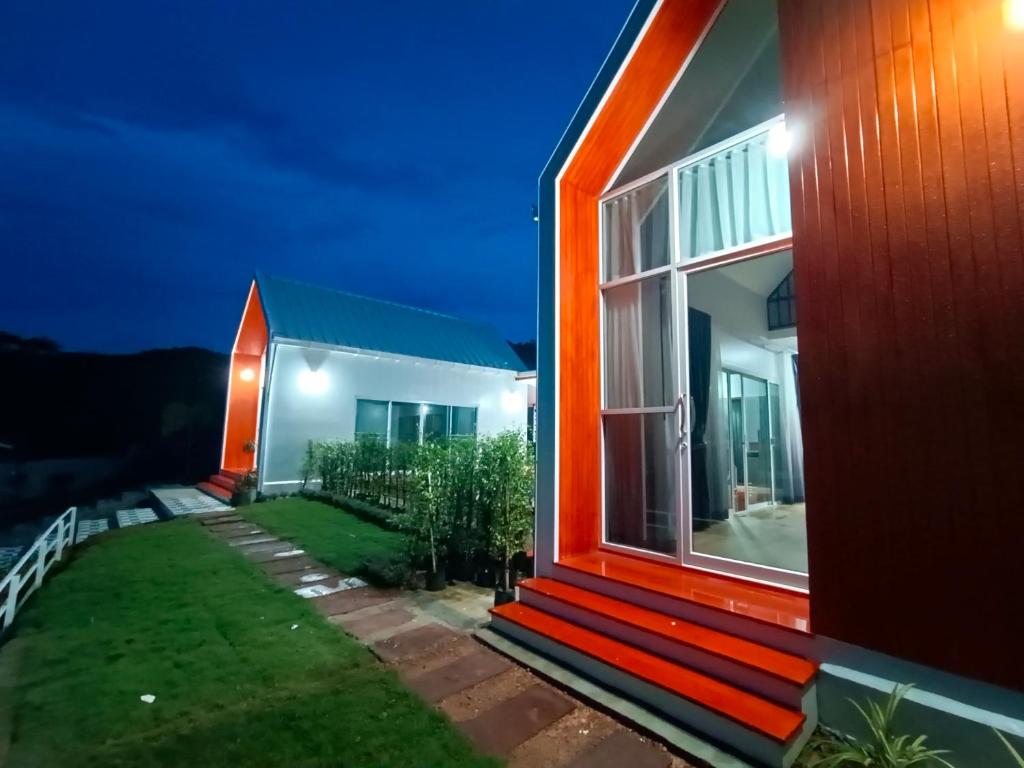 une maison avec une façade orange la nuit dans l'établissement อัญมัน ลันตา Anyaman Lanta, à Ko Lanta