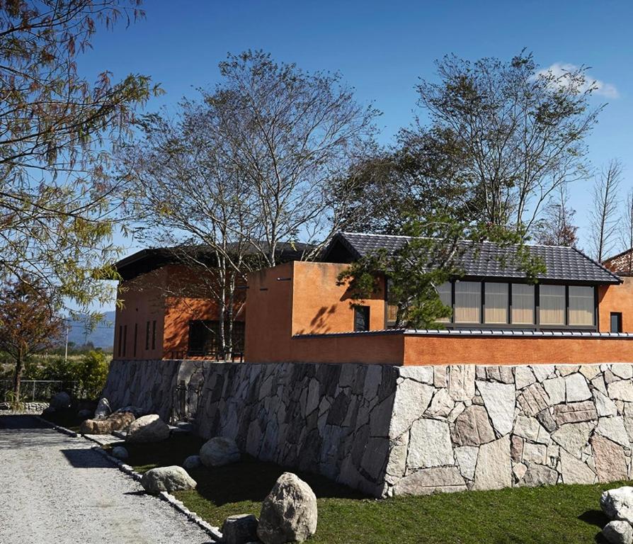 Holiu Resort في Nan-p'ing-li: منزل بحائط حجري بجانب طريق