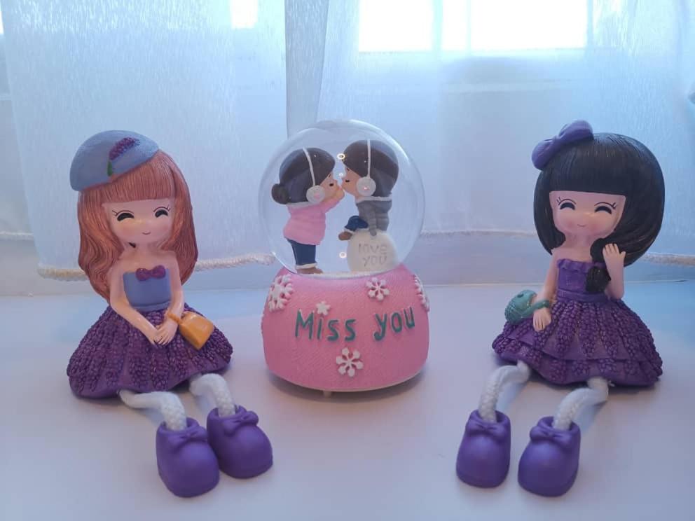 a group of toy dolls sitting next to a glass dome at Homestay TW BSI near Tawau Airport in Kampong Parit